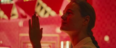 Kadının elleri cam üzerinde, içinde büyüleyici lüks eşyalar olan parlak bir ekrana bakıyor..