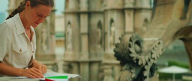 Kadın mermer terasta şehir haritası okuyor. Arka planda Milan Katedrali var..