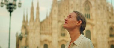 Sıcak güneş ışığında gotik mimariye hayran olan mutlu kadın..