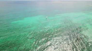 Parlak turkuaz Karayip denizi üzerinde süzülen yelkenli, hava aracı manzarası.