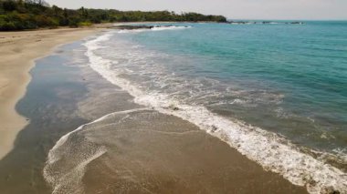 Nazik turkuaz dalgaları ve Kosta Rika 'da koyu kumlu sakin tropikal plajlar..