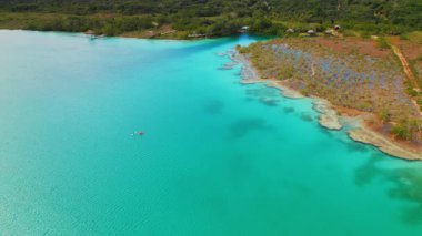 Meksika 'daki Bacalar lagününün parlak mavi sularında kürek çeken kayakçılar..
