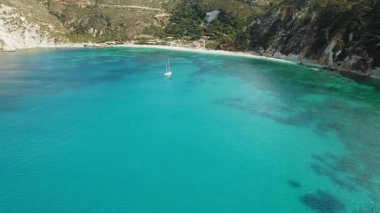 Petani sahili yakınlarındaki turkuaz sularda kıyıya yanaşan yelkenli..