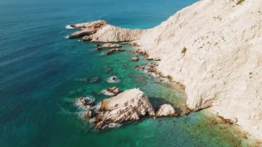 Kefalonya 'nın beyaz uçurum kıyısındaki turkuaz sudan yükselen kaya oluşumu.