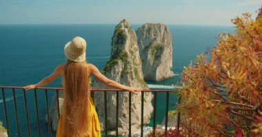 Manzaralı Capri deniz manzaralı Faraglioni uçurumlarına hayran bir kadın turist..