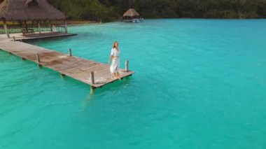 Meksika Bacalar lagününün sonunda duran esintinin tadını çıkaran kadın..