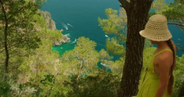 Capri İtalya 'da yürüyüş sırasında denizi seyreden ve orman ağaçlarında tekne gezdiren bir kadın..
