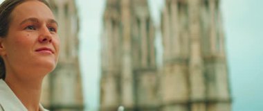 Bulanık katedral kuleleri olan mimariyi izleyen düşünceli bir kadın..