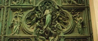 Detaylı bronz kapı paneli melekler ve Meryem Ana 'nın bebek İsa' yı tuttuğu dini sahneleri gösteriyor..