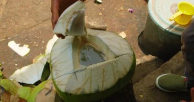 Taze hindistan cevizi Bali Endonezya 'da yerel bir pazar yerinde elle açılıyor..