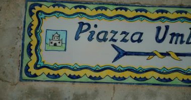 Capri İtalya 'da bir yaz gününde I. Piazza Umberto' yu gösteren seramik tabela..