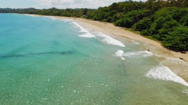 Güneşli bir günde Kosta Rika 'da uzun tropikal sörf plajı.