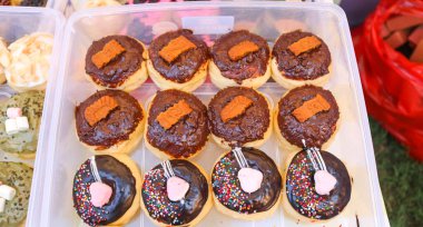 Çeşitli aromalı ve malzemeli çörekler. Konteynıra yerleştirilmiş bir donut koleksiyonu..