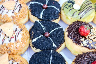 Çeşitli aromalı ve malzemeli çörekler. Konteynıra yerleştirilmiş bir donut koleksiyonu..