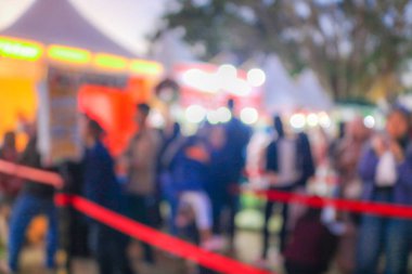 Gece festivali şehir parkının arka planındaki bulanık insanlar. Gece pazarındaki kalabalığın bulanık fotoğrafı ve yiyecek tezgahları.