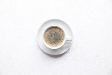 Beyaz bir masada köpüklü sade kahve.