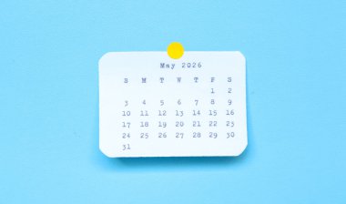 Mayıs 2026 tarihli bir kağıt çıkartması mavi arka plana yerleştirilmiş. Mavi arka plana iliştirilmiş bir Mayıs 2026 çıkartması. Asgari ve temiz takvim kavramı.
