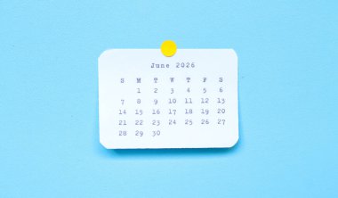 Haziran 2026 'yı gösteren bir kağıt çıkartması mavi arka plana yerleştirilmiş. Mavi arkaplana iliştirilmiş Haziran 2026 çıkartması. Asgari ve temiz takvim kavramı.