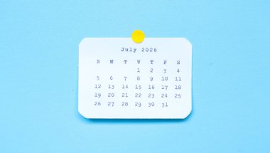 Temmuz 2026 'yı gösteren bir kağıt çıkartması mavi arka planda. Mavi arkaplana iliştirilmiş Temmuz 2026 çıkartması. Asgari ve temiz takvim kavramı.
