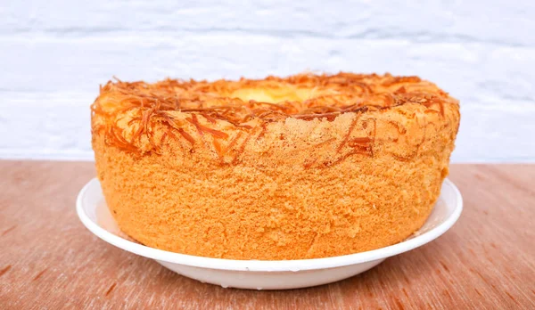 Beyaz tabakta peynir aromalı şifonlu kek. Masada ızgara peynirli taze pişmiş şifon kabarık kek.