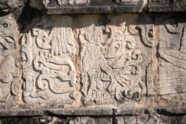 Meksiko 'daki Chichen Itza' da antik Maya mimarisini gözler önüne seren canlı mavi gökyüzüne karşı Venurs Tstand 'ın tarihi platformunun ayrıntılı görüşleri..
