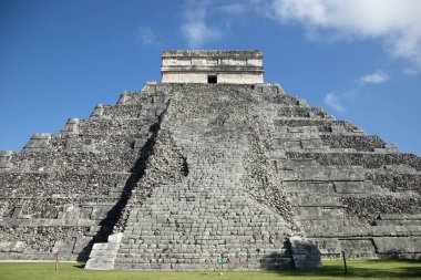 The iconic El Castillo pyramid, also known as the Temple of Kukulcan, stands majestically against a vibrant blue sky, showcasing its ancient Mayan architecture at Chichen Itza in Mexico.