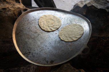 Geleneksel mısır tortillaları açık odun ateşinde kuyrukluyıldızda pişiyor.