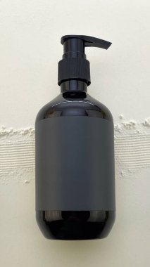 Kozmetik, sabun, cilt bakımı ya da marka modeli için Beyaz desenli arka plan üzerinde Boş Etiketli Asgari Siyah Pompa Şişesi