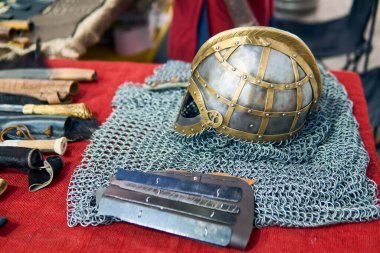 Ortaçağ süslemelerine oldukça detaylı bir bakış açısı. Antika bir stil, bıçaklar, bir kask, İskandinav sembolleri, aksesuarlar, ütüler ve bir kılıç. Ortaçağ şövalye kıyafetleri ve aksesuarları..                               