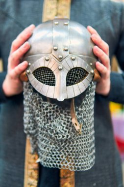Bir ortaçağ savaşçısının miğferi ellerinden sergileniyor. Oldukça detaylı, zincirli ve çok iyi korunmuş bir metal miğfer. Bir ortaçağ savaşçısının kasklı elleri..                               