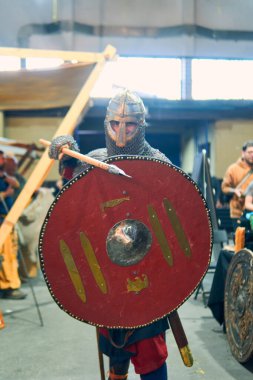 Kılıçlı, aksesuarlı ve parlak zırhlı bir ortaçağ şövalyesinin portresi, savaşa hazır ve nazır. Ortaçağ konsepti, Vikingler, savaş.                               