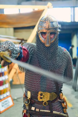 Kılıçlı, aksesuarlı ve parlak zırhlı bir ortaçağ şövalyesinin portresi, savaşa hazır ve nazır. Ortaçağ konsepti, Vikingler, savaş.                               