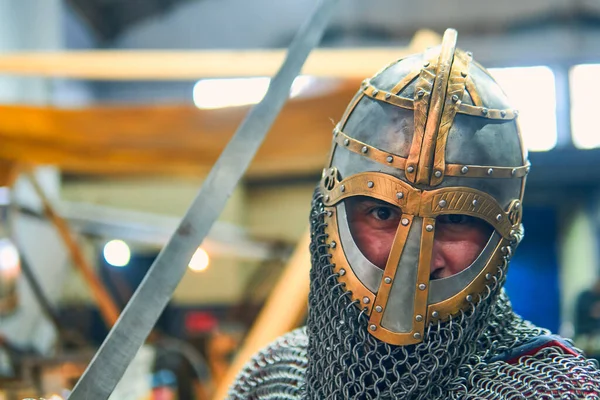 Kılıçlı, aksesuarlı ve parlak zırhlı bir ortaçağ şövalyesinin portresi, savaşa hazır ve nazır. Ortaçağ konsepti, Vikingler, savaş.                               