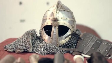 Ortaçağ süslemelerine oldukça detaylı bir bakış açısı. Antika bir stil, bıçaklar, bir kask, İskandinav sembolleri, aksesuarlar, ütüler ve bir kılıç. Ortaçağ şövalye kıyafetleri ve aksesuarları..