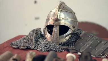 Ortaçağ süslemelerine oldukça detaylı bir bakış açısı. Antika bir stil, bıçaklar, bir kask, İskandinav sembolleri, aksesuarlar, ütüler ve bir kılıç. Ortaçağ şövalye kıyafetleri ve aksesuarları..