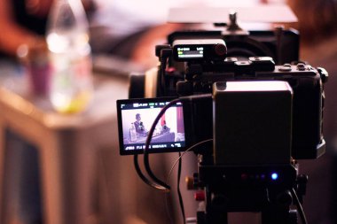 Bir görsel-işitsel yapım sahnesinin arkasında, filmleri kaydediyor ve onları ekranlar ve kameralar aracılığıyla izliyor. Yönetmen ve yapım ekibinin görüşü.