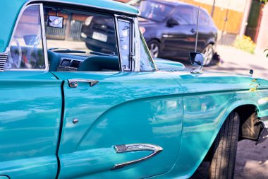 Kırmızı ışıkları olan güzel bir antika turkuaz araba. İyi bakımlı ve iyi boyanmış bir araç, yenilenmiş. Yan taraftan görüldü. Gün batımında parka park ettim, doğal ışıkla..