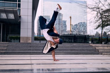 Genç yetişkinler bazı binaların önünde coşkuyla dans eder, amuda kalkarlar, kot pantolon ve şehir kıyafetleri giyerler, bir sürü tavır, hareket ve iyi enerji. Sokak dansı, serbest stil, modern dans..
