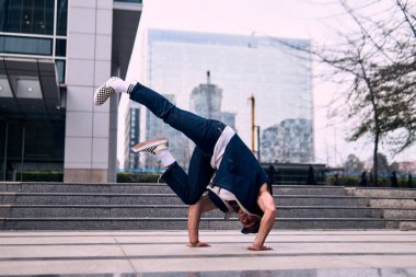 Genç yetişkinler bazı binaların önünde coşkuyla dans eder, amuda kalkarlar, kot pantolon ve şehir kıyafetleri giyerler, bir sürü tavır, hareket ve iyi enerji. Sokak dansı, serbest stil, modern dans..