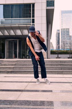 Genç, zinde bir yetişkin coşkuyla break dans yapıyor, zıplıyor, ritim tutuyor. Kot pantolon ve şehir kıyafetleri giymişti. Bir sürü tavır, hareket ve iyi enerji. Sokak dansı, serbest stil, modern dans..