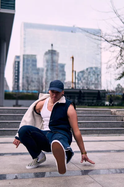 Genç yetişkinler binaların önünde coşkuyla dans eder, yerde döner, kot pantolon ve şehir kıyafetleri giyer. Bir sürü tavır, hareket ve iyi enerji. Sokak dansı, serbest stil, modern dans..