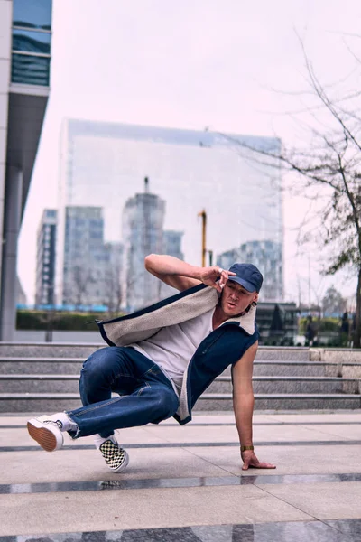 Genç yetişkinler binaların önünde coşkuyla dans eder, yerde döner, kot pantolon ve şehir kıyafetleri giyer. Bir sürü tavır, hareket ve iyi enerji. Sokak dansı, serbest stil, modern dans..