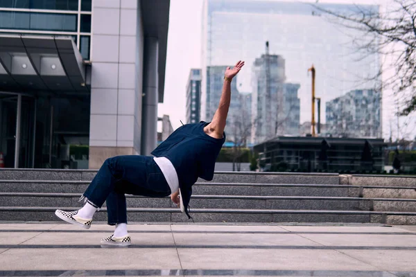 Genç yetişkinler binaların önünde coşkuyla dans eder, yerde döner, kot pantolon ve şehir kıyafetleri giyer. Bir sürü tavır, hareket ve iyi enerji. Sokak dansı, serbest stil, modern dans..