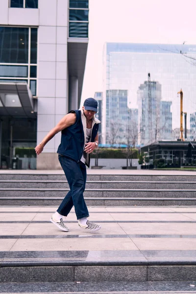 Genç, zinde bir yetişkin coşkuyla break dans yapıyor, zıplıyor, ritim tutuyor. Kot pantolon ve şehir kıyafetleri giymişti. Bir sürü tavır, hareket ve iyi enerji. Sokak dansı, serbest stil, modern dans..