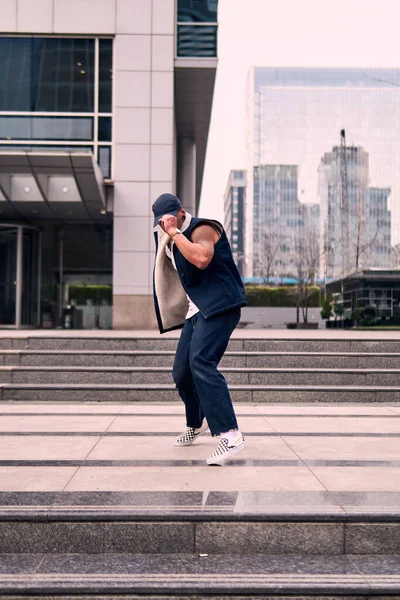 Genç, zinde bir yetişkin coşkuyla break dans yapıyor, zıplıyor, ritim tutuyor. Kot pantolon ve şehir kıyafetleri giymişti. Bir sürü tavır, hareket ve iyi enerji. Sokak dansı, serbest stil, modern dans..