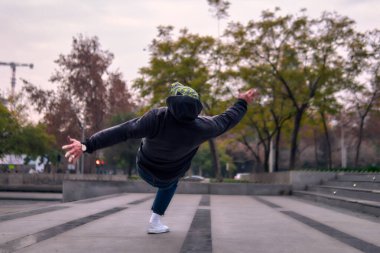 Genç yetişkinler coşkuyla dans eder, amuda kalkar ve yerde döner. Kot pantolon, sokak kıyafeti ve şapka giyiyor. Bir sürü tavır, hareket ve iyi enerji. Sokak dansı, serbest stil ve modern dans..
