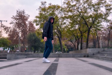 Genç yetişkinler coşkuyla dans eder, yürür, dinlenir ve kötü çocuk pozları verir. Kot pantolon, sokak kıyafeti ve şapka giyiyor. Bir sürü tavır, hareket ve iyi enerji. Serbest stil ve modern dans.