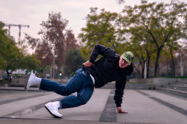 Genç yetişkinler coşkuyla dans eder, amuda kalkar ve yerde döner. Kot pantolon, sokak kıyafeti ve şapka giyiyor. Bir sürü tavır, hareket ve iyi enerji. Sokak dansı, serbest stil ve modern dans..