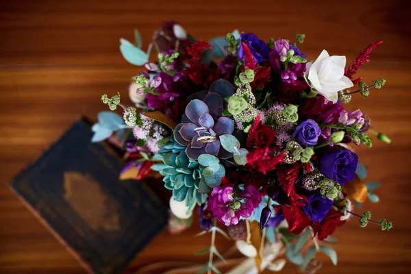Свадебный букет и обручальные кольца на деревянном столе. Instagram в тонусе . — стоковое фото
