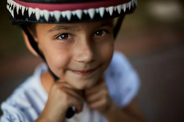 Niño poniéndose un casco de bicicleta, la seguridad primero — Foto de Stock